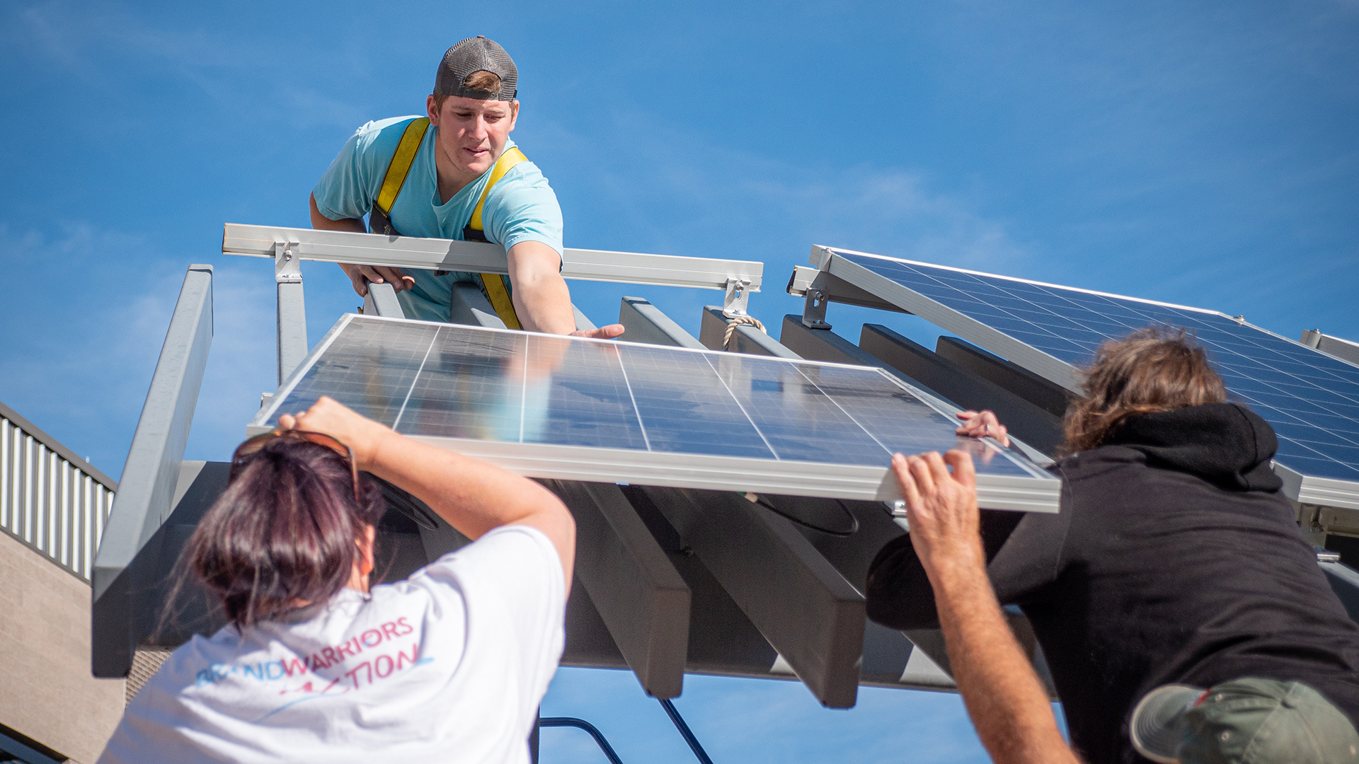 four construction students installing a solar panel